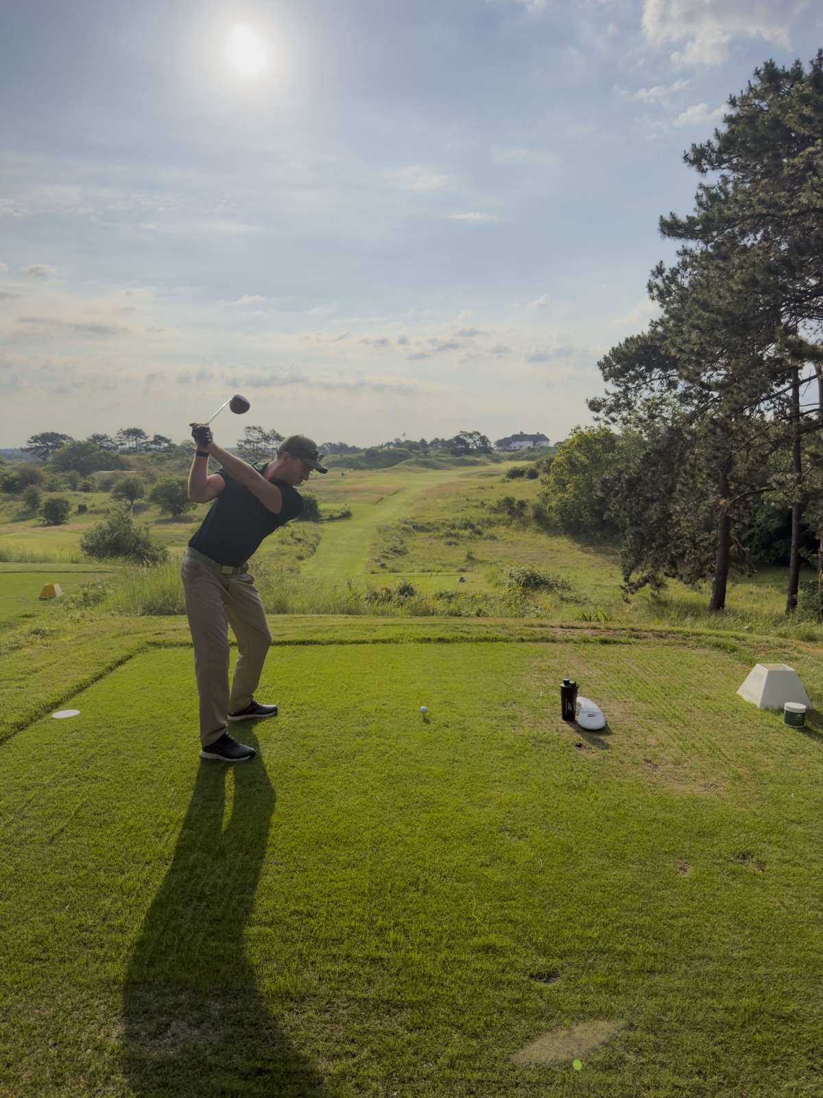 Golfer maakt een volledige swing tegen het ochtendlicht
